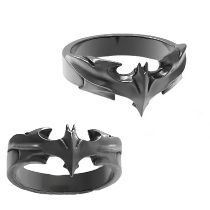 Two metallic bat-shaped rings on a white background