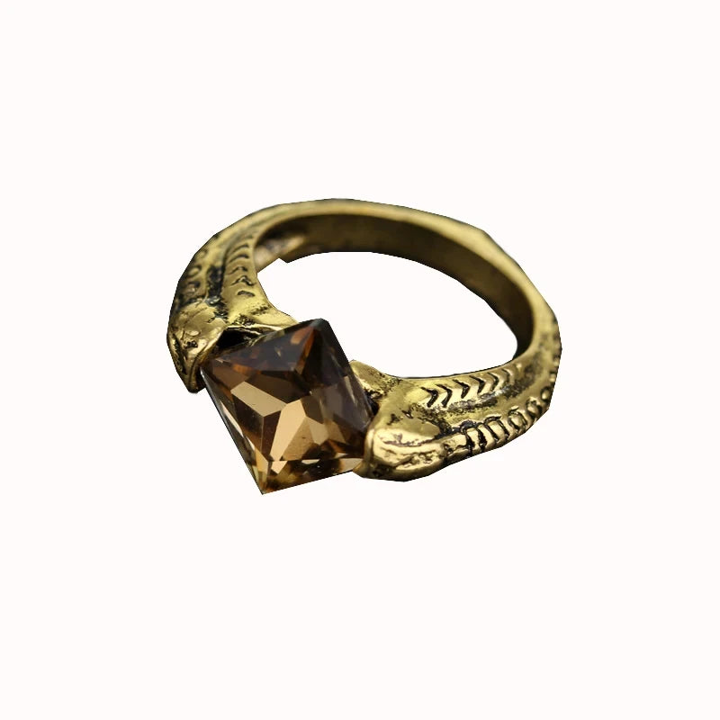 Close-up of Lord Voldemort’s Horcrux ring featuring a gold-tone serpent band and a faceted smoky brown Resurrection Stone.