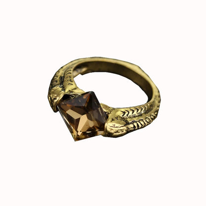 Close-up of Lord Voldemort’s Horcrux ring featuring a gold-tone serpent band and a faceted smoky brown Resurrection Stone.