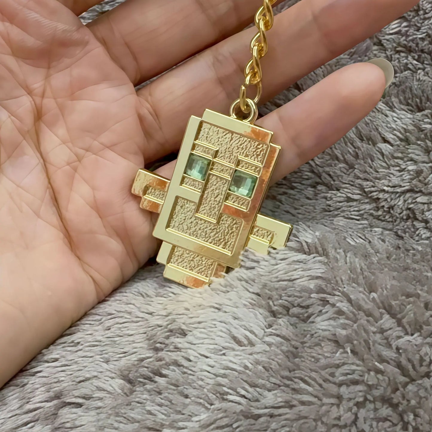 gold keychain of a totem of undying from video game minecraft