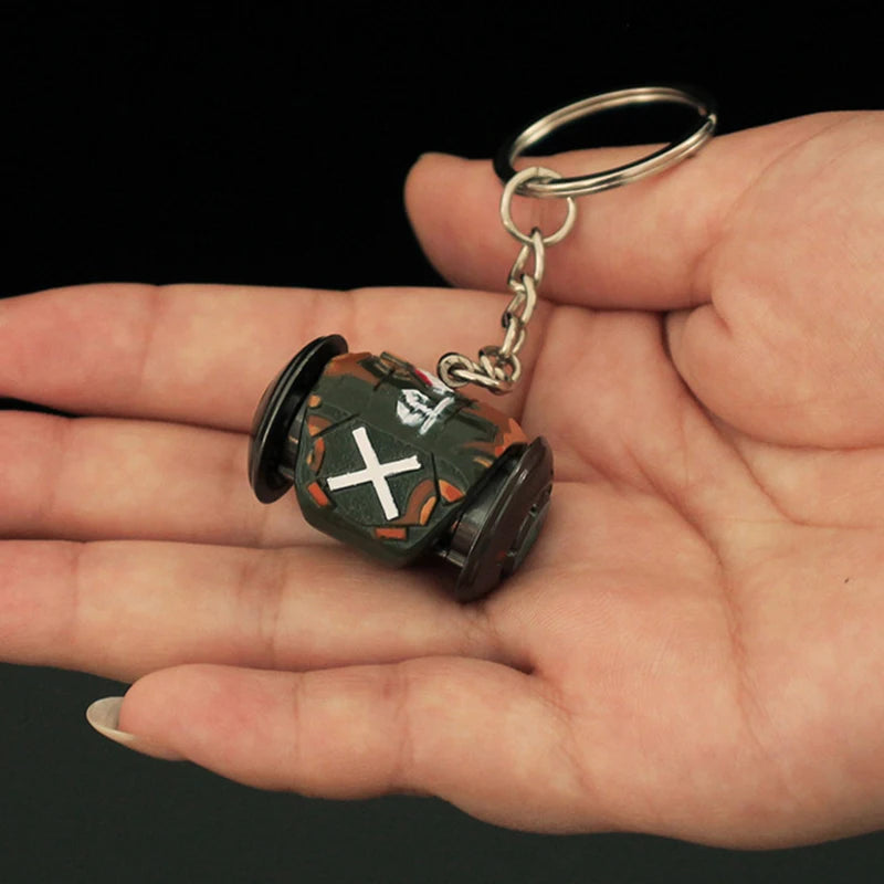 Keychain resembling a small vehicle held in a hand against a dark background