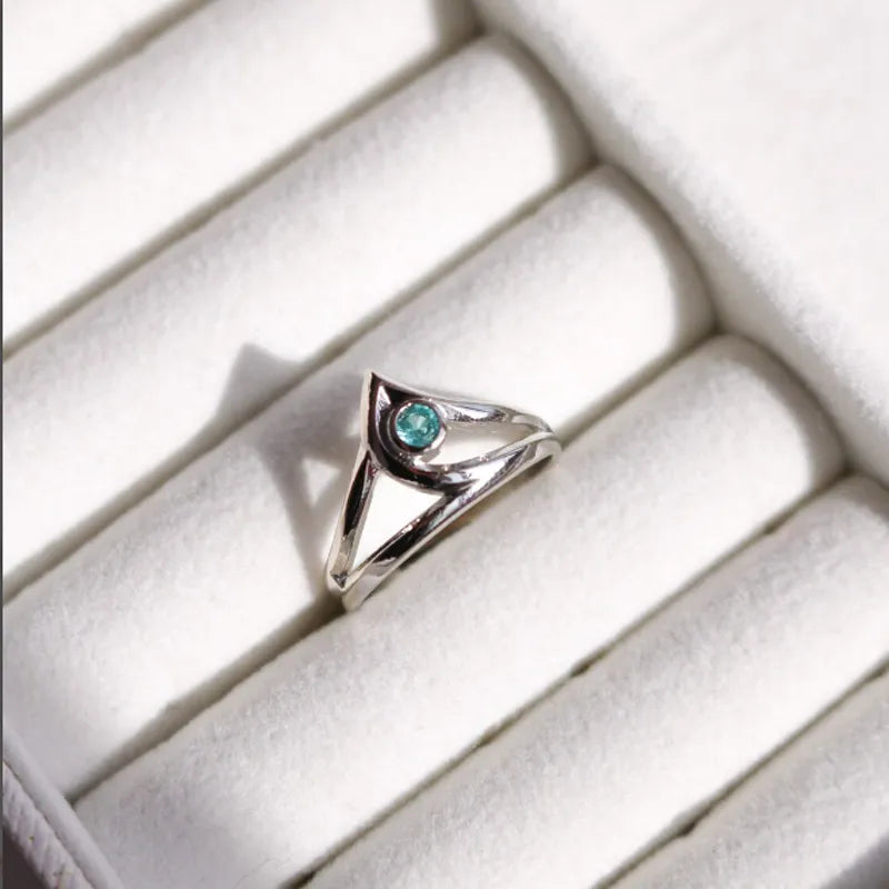 Silver ring with a blue gemstone on a white cushion from Valorant