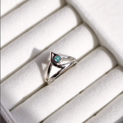 Silver ring with a blue gemstone on a white cushion from Valorant